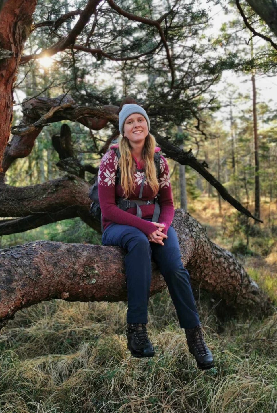 Silvia Sandnes på skogstur, sitter på furugrein og slapper av.